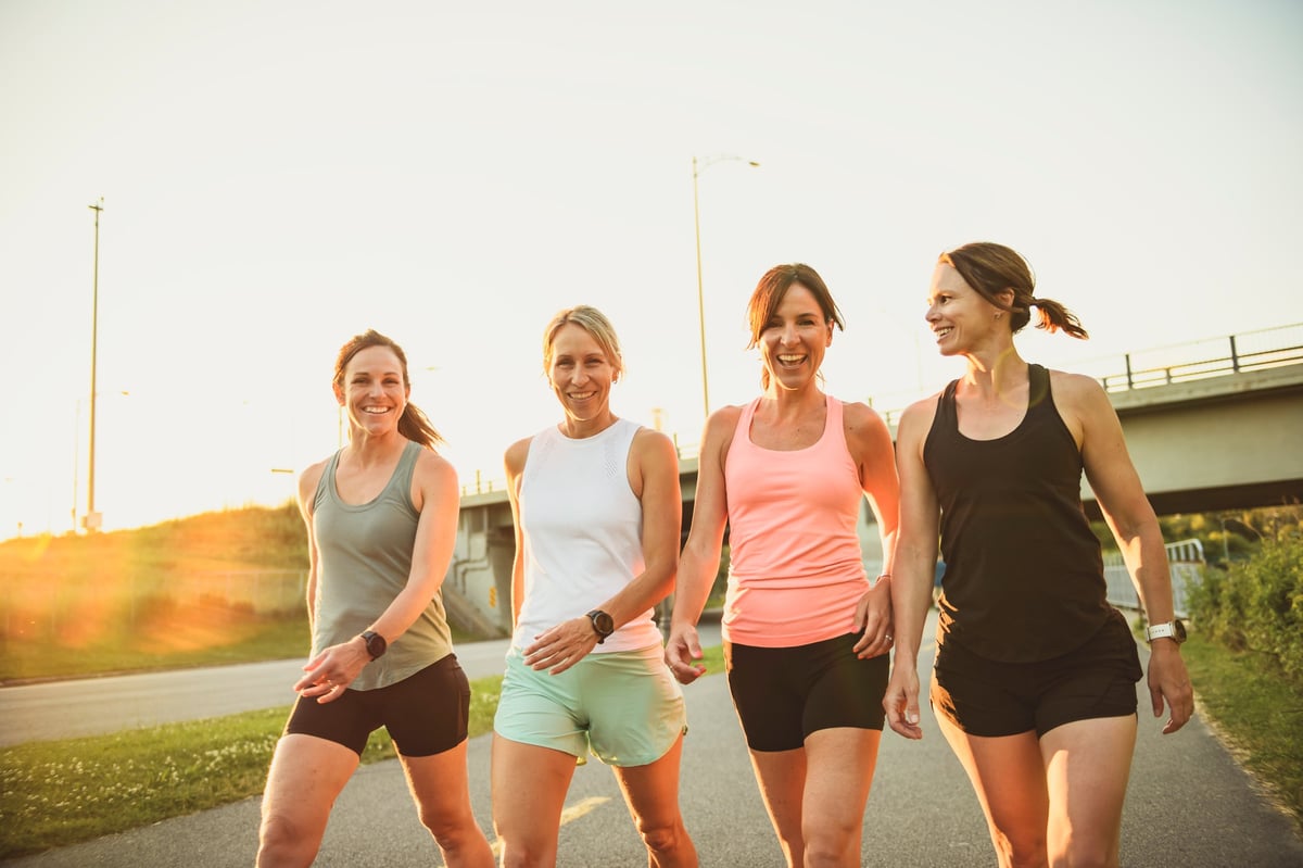 Females in sportswear walking together in sunny park